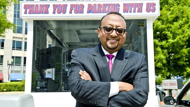 Henok Tesfaye standing beside a parking booth